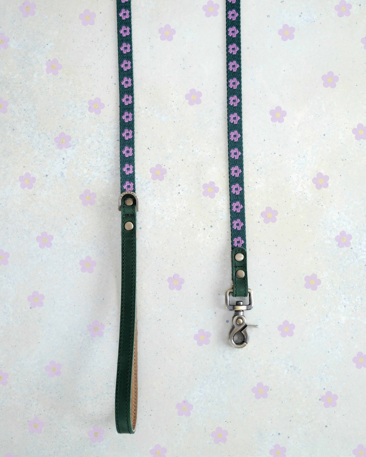 Two thin webbing leashes in green and lilac hanging side by side