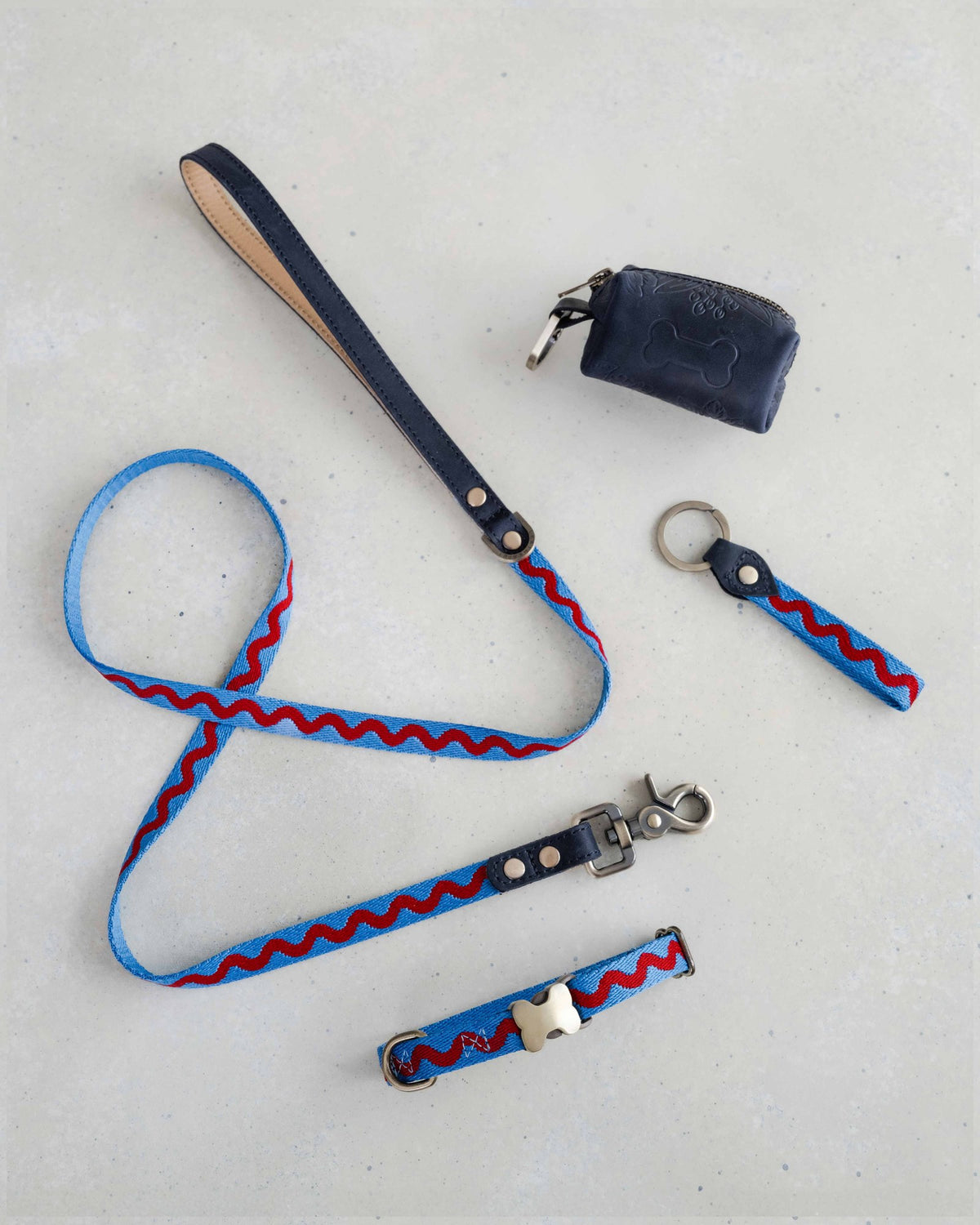 Thin webbing leash in blue ric rac with a matching collar, keychain and leather bag holder