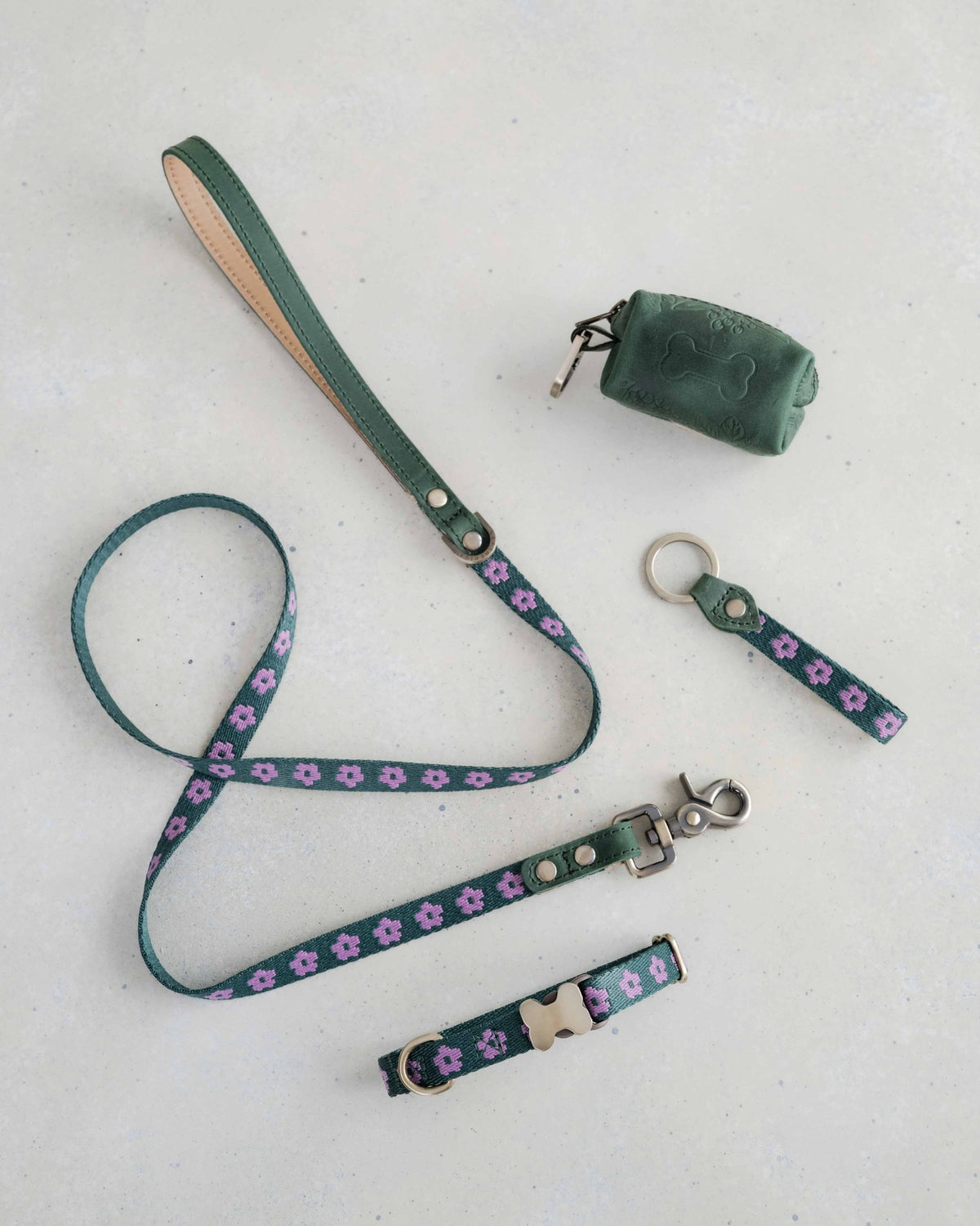 Thin webbing leash in green and lilac with a matching collar, keychain and leather bag holder