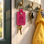 Bright pink This house RUNS ON MOM keychain on house keys beside a busy family calendar
