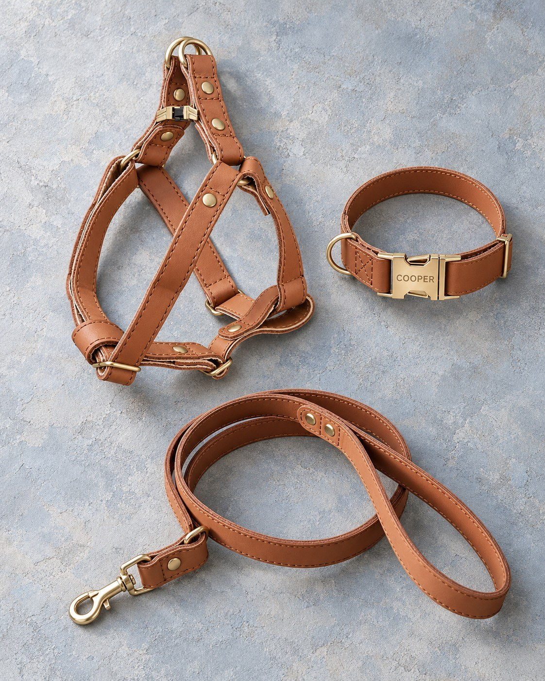 Matching leather dog harness, collar and leash set in Caramel laid flat