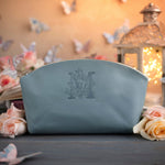 Turquoise leather makeup bag with a floral initial deboss