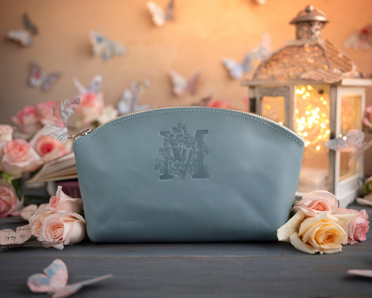 Turquoise leather makeup bag with a floral initial deboss