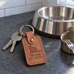 Caramel Vet Says Big Boned keychain on a kitchen counter beside a bag of cat treats