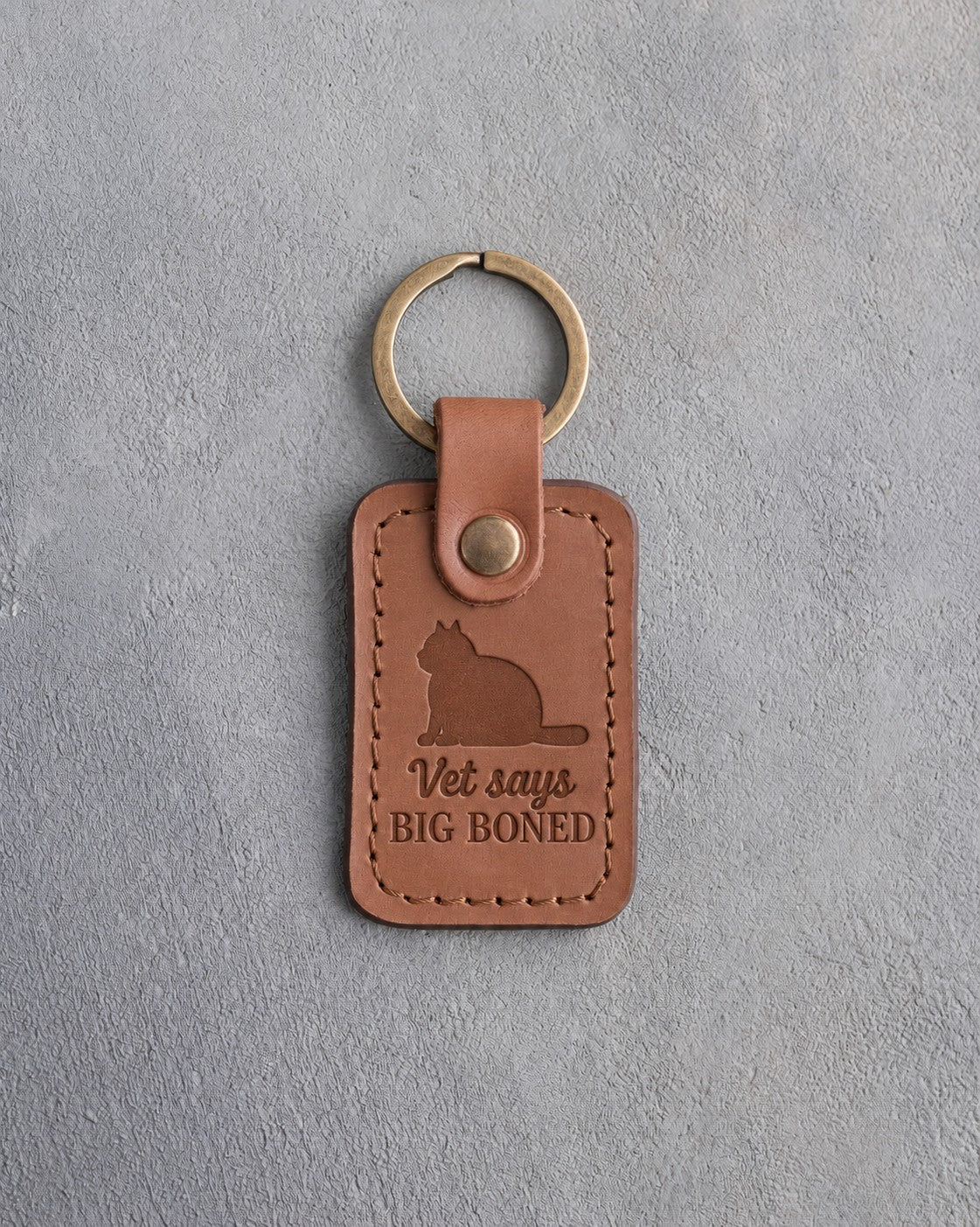 Caramel leather keychain debossed with a heavy round tomcat above the words Vet says BIG BONED