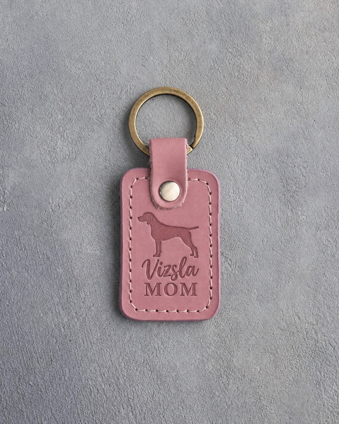 Parisian Blossom pink leather keychain with a debossed vizsla and the words Vizsla MOM, on gray concrete