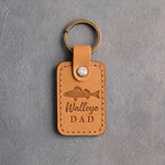 Indian summer leather keychain debossed with a walleye above the words Walleye DAD, on gray plaster
