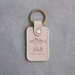 Gray sand leather keychain debossed with a walleye above Walt and WALLEYE, on gray plaster