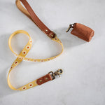 Sunny Daisy woven webbing dog leash with a brown leather handle and matching poop-bag holder