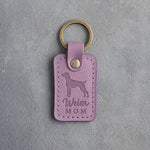 Lilac leather keychain with a debossed weimaraner and the words Weim MOM on gray concrete