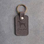 Country gray leather keychain debossed with a weimaraner above Gray ghost and THE WEIM, on gray concrete