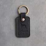 Black leather keychain debossed with a whippet silhouette and Whippet DAD on gray concrete