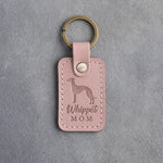 Blush pink leather keychain with a debossed whippet and the words Whippet MOM, on gray concrete