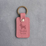 Parisian Blossom pink leather keychain debossed with a Yorkshire Terrier silhouette and the words Yorkie MOM, on gray concrete