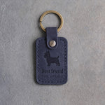 Blueberry navy leather keychain debossed with a Yorkshire Terrier silhouette above Best friend and THE YORKIE, on gray concrete