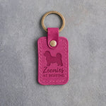 Fuchsia pink leather keychain debossed with a Havanese and the words Zoomies AT BEDTIME, on gray concrete
