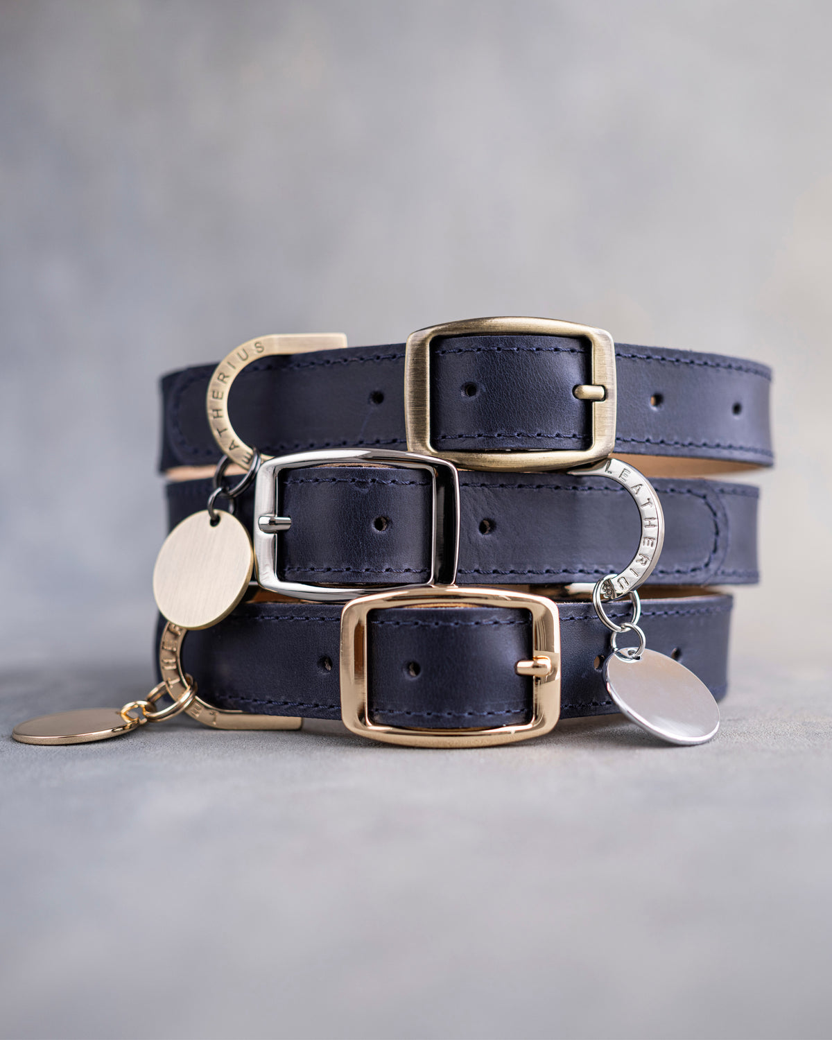 Dog collar in blueberry navy leather with a classy pin buckle and brass ID tag, three stacked