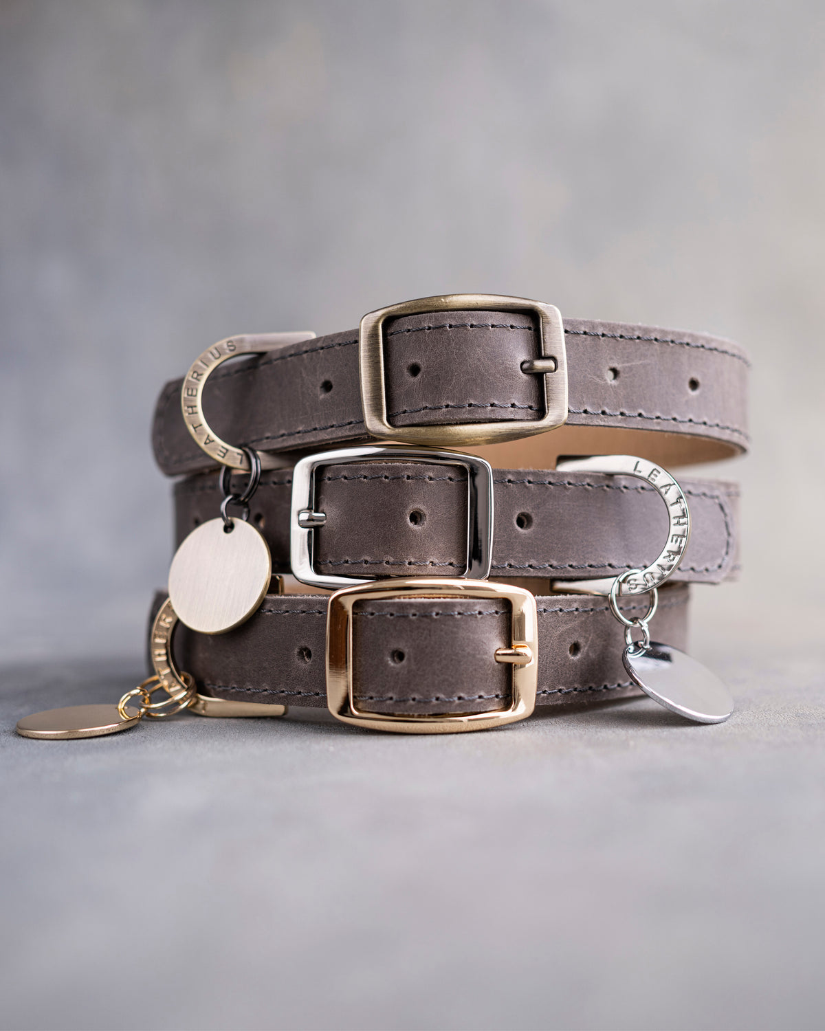 Dog collar in country gray leather with a classy pin buckle and brass ID tag, three stacked