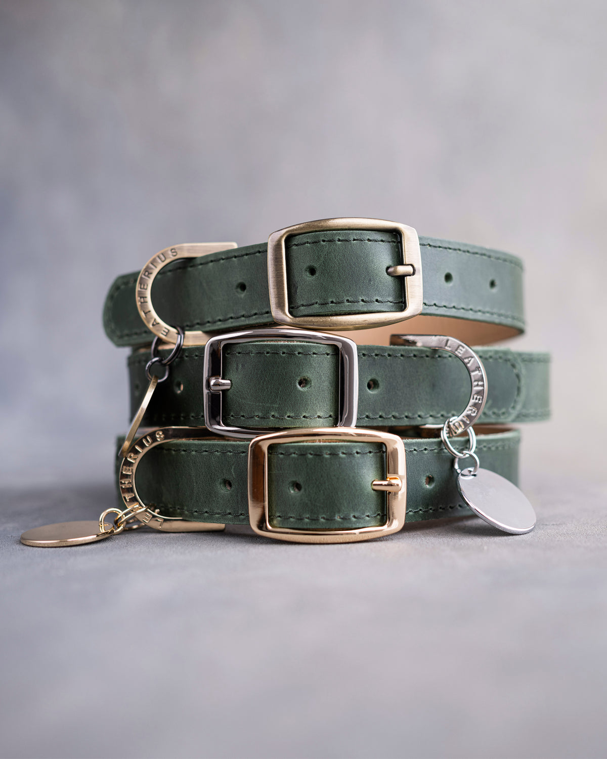 Dog collar in forest green leather with a classy pin buckle and brass ID tag, three stacked