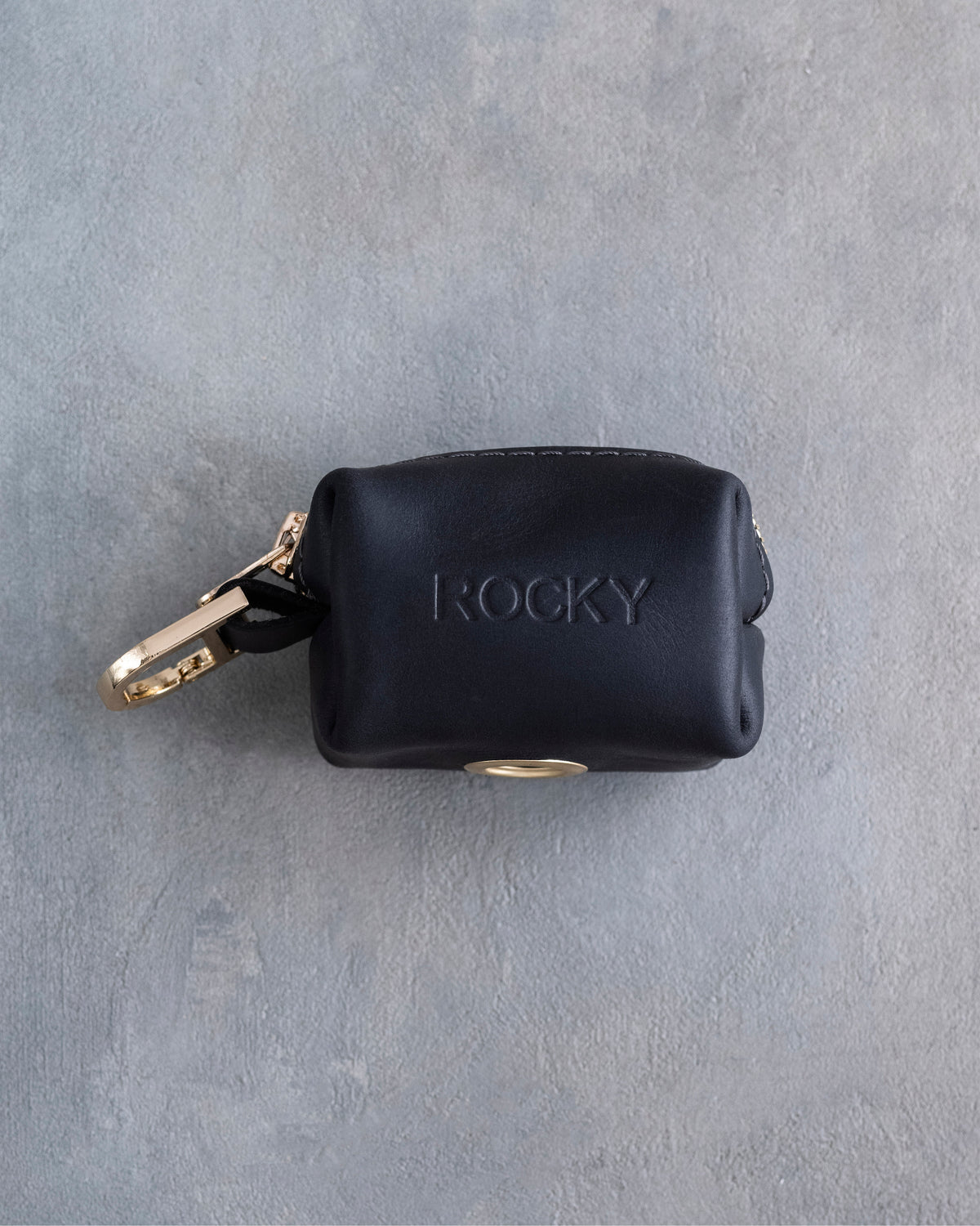 Black leather dog poop bag holder with an engraved name and brass clip